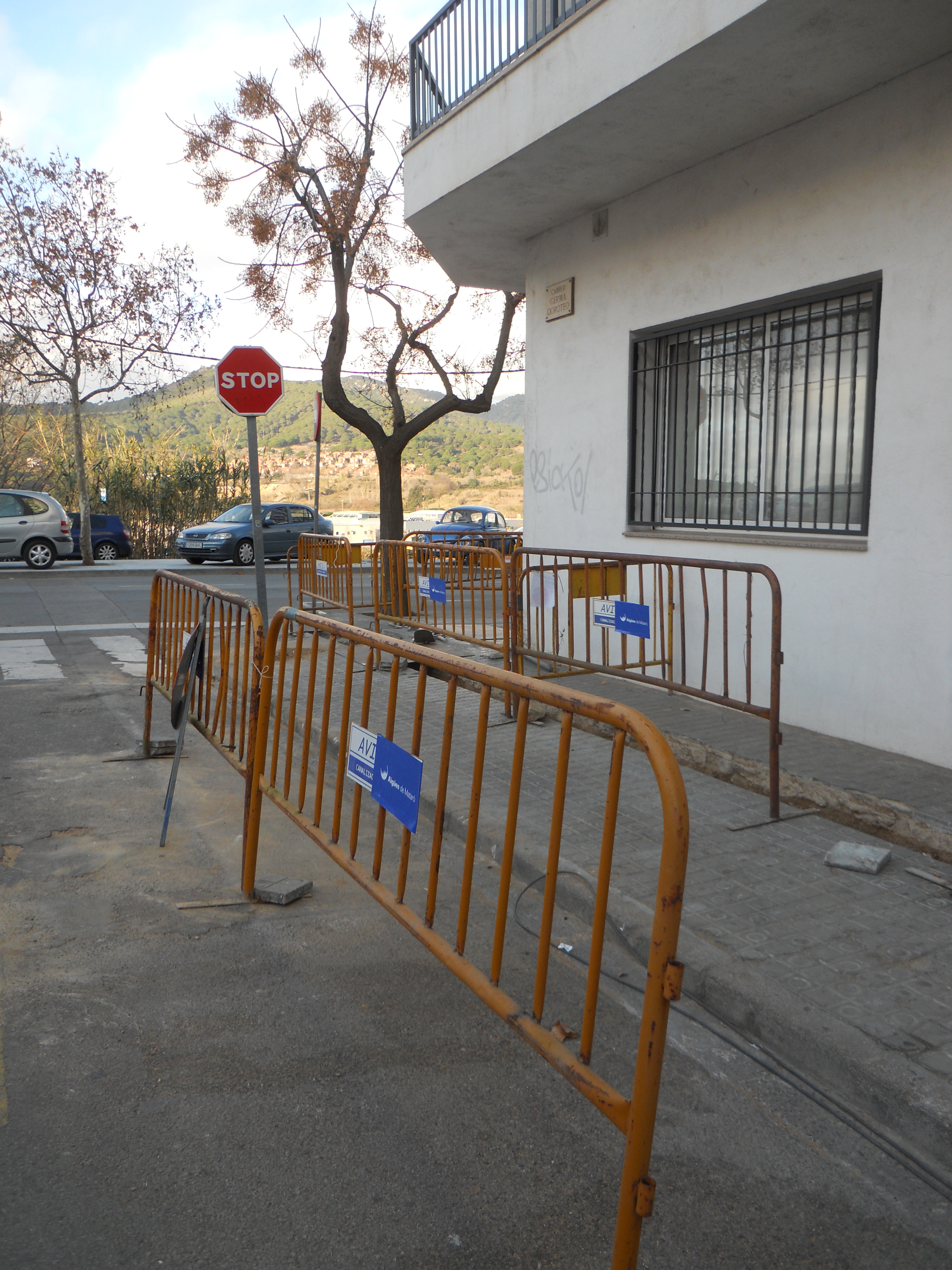 Dues tanques d'obres color groc protegint vorera del carrer de Germà Doroteo