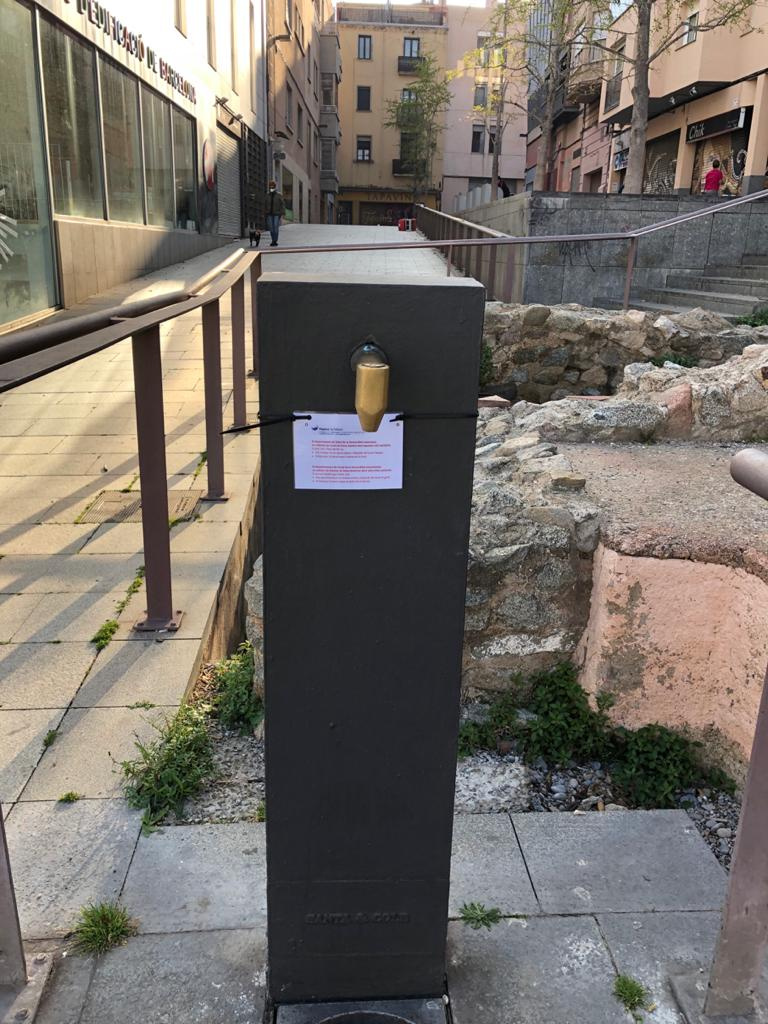 Font situada a la plaça de la Muralla amb cartell informatiu de precaucions d'ús a causa de la COVID