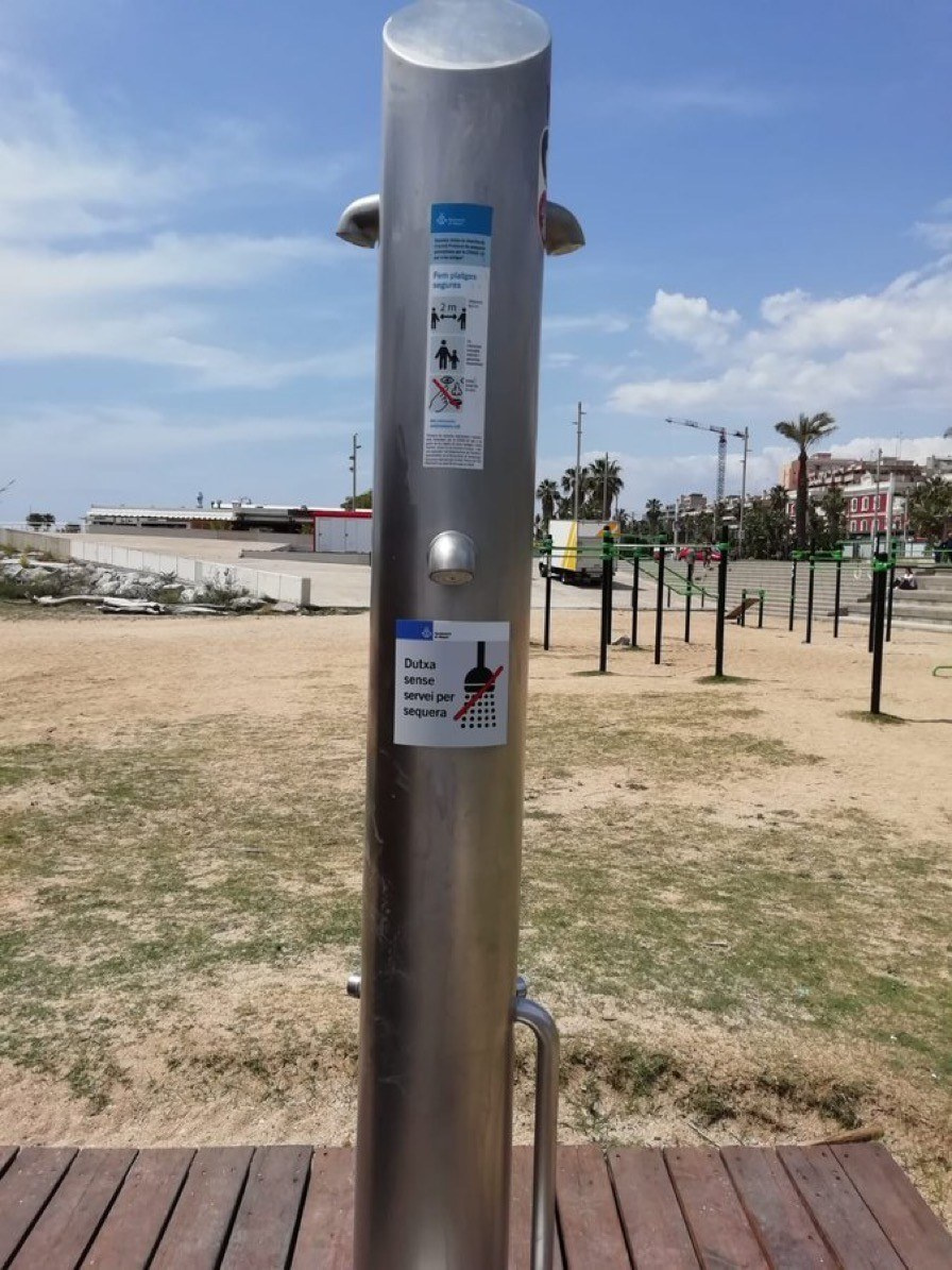 Dutxa de la platja de Mataró amb cartell sobre tall d'aigua i les restricciones per sequera