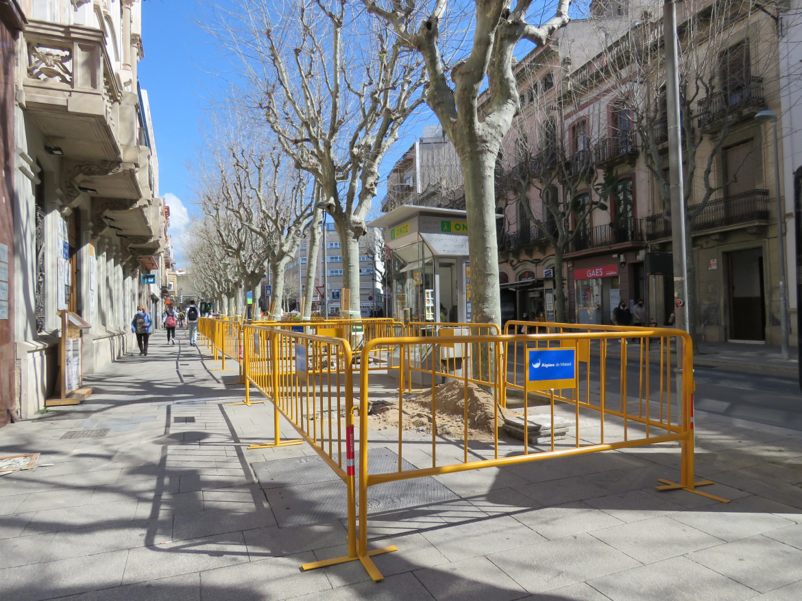 Rases obertes a la Rambla de Mataró, protegides per tanques d'obres i persones caminant per la vorera