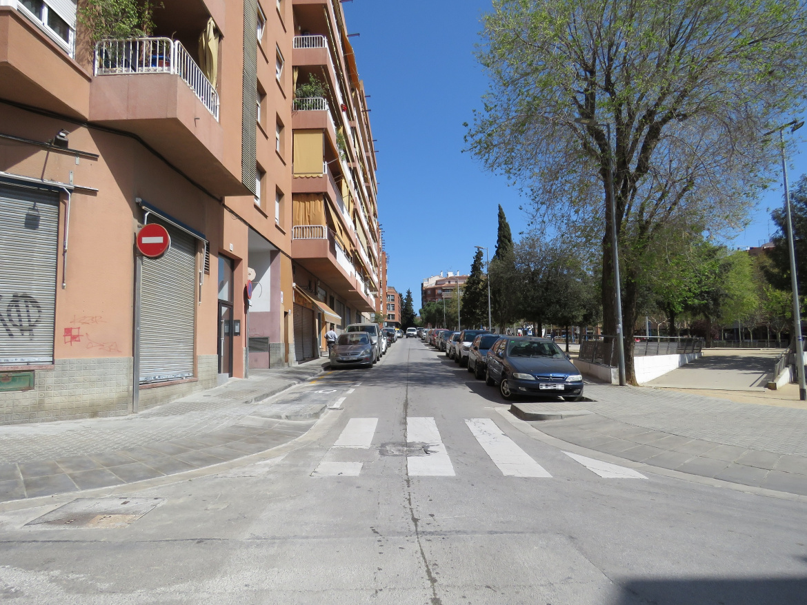 Pas de vianants amb cotxes aparcats als dos laterals de la vorera que envolta la Plaça de Catalunya