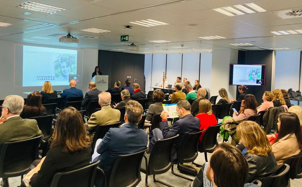 Persones en sala plena de cadires escoltant presentació sobre Economia Circular