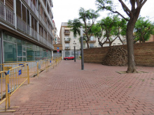 Plaça d'Antoni Gaudí amb escultura de maons i tanques d'obres d'Aigües de Mataró a la dreta