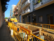 Operaris amb casc i vestits reflectants treballant en rasa oberta al carrer