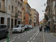 Camí Ral de la Mercè on es veu filera de cotxes a la calçada i vianants caminant per la vorera.