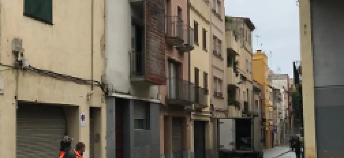 Carrer de sant Ramon acabat d'urbanitzar amb dos operaris en primer pla