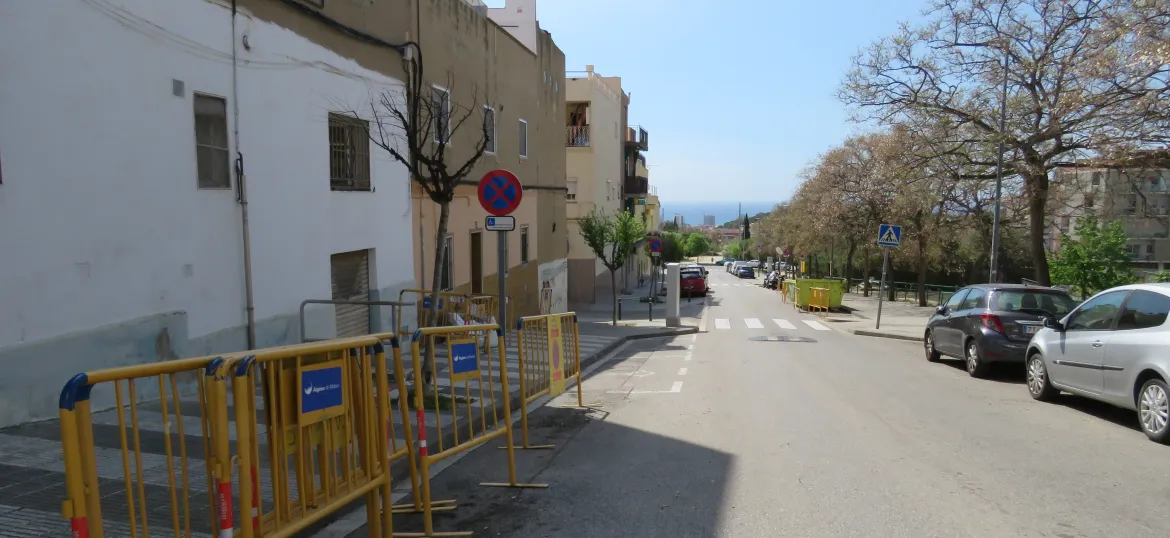 Carrer de la Immacxulada amb tanques d'obres color groc a la dreta