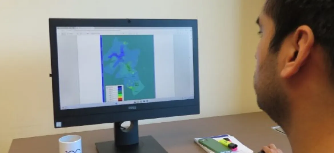 Doctorat industrial teballant davant d'un ordinador, amb un model de l'aquïfer en pantalla