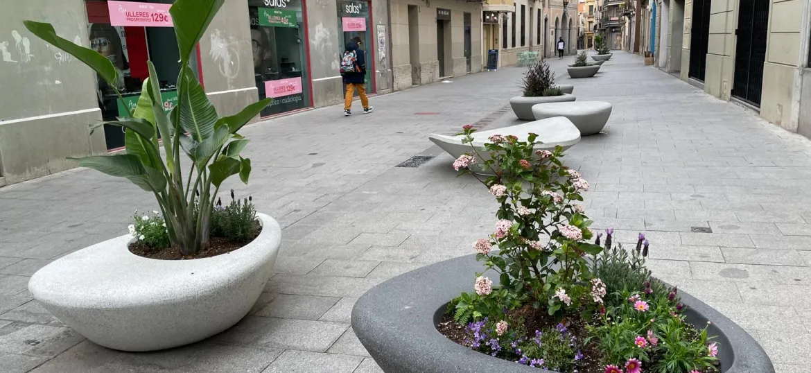 Carrer de Sant Josep amb jardineres ovalades en primer pla