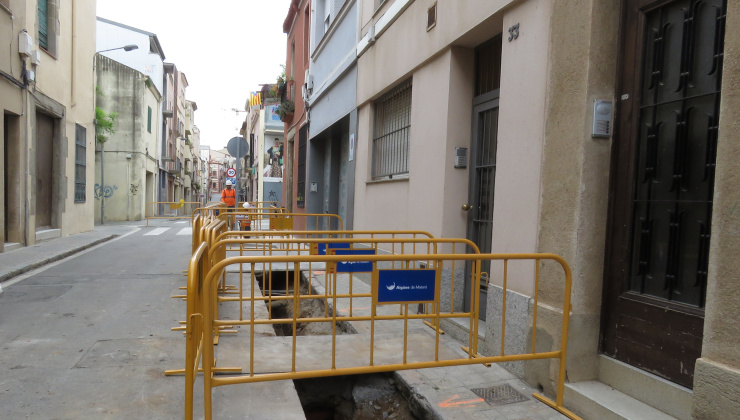 Rases obertes a l'asfalt del carrer de Sant ramon amb tanques que les protegeixen, al costat de les entrades d'uns habitatgesjpg
