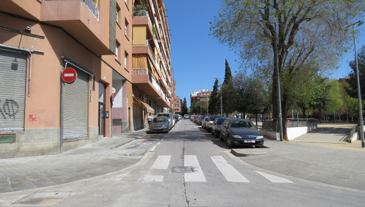 Pas de vianants amb cotxes aparcats als dos laterals de la vorera que envolta la Plaça de Catalunya